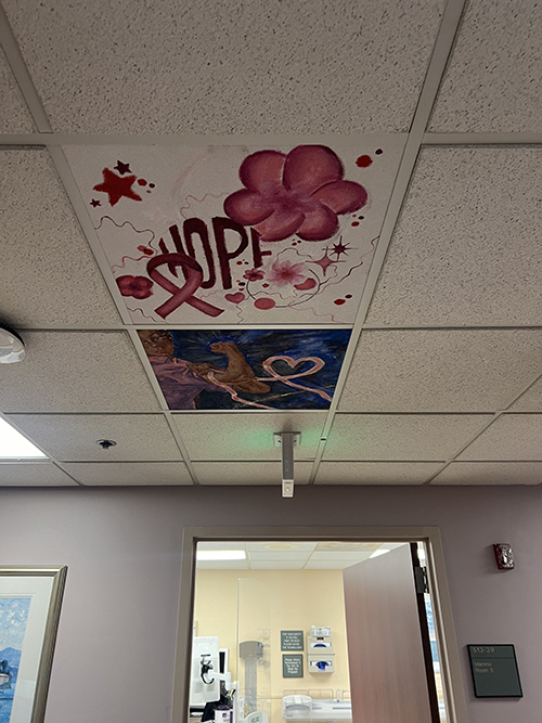 Beautiful ceiling tiles painted with flowers and breast cancer logos by students