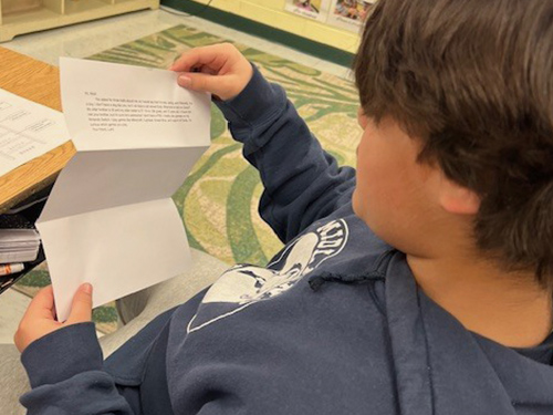 High school student reading a letter from his pen pal